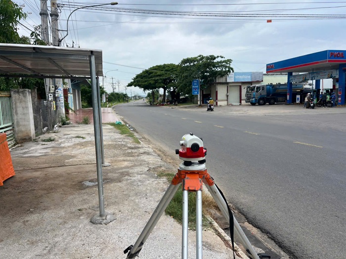 Máy toàn đạc khảo sát địa hình đặt bên tuyến đường tại xã Hàm Liêm, Lâm Đồng