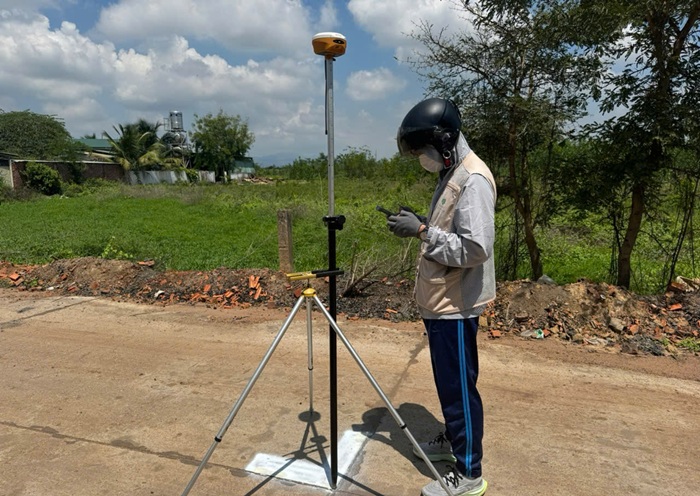 Kỹ thuật viên kiểm tra dữ liệu GNSS tại khu đất ven đường ở Tân Lập, Lâm Đồng