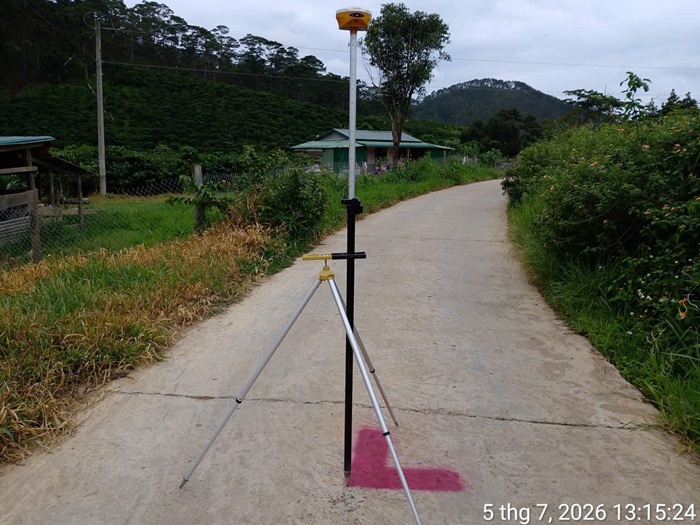 Thiết bị GNSS trên đường bê tông giữa vùng cây và đồi tại xã Tà Năng