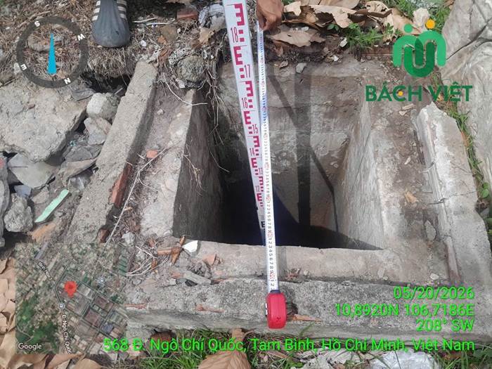 Thước dựng trong hố bê tông giữa nền đất và gạch vụn tại SaiGon Metal