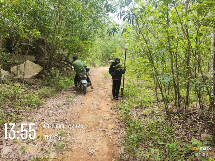 Người khảo sát cầm sào GNSS trên lối mòn rừng Châu Pha